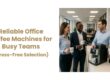 Admiral Vending - Blog - Reliable Office Coffee Machines for Busy Teams - Image of office members standing by coffee machine chatting and smiling